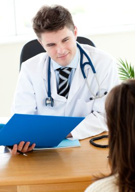 Self-assured doctor reading a report with a female patient clipart