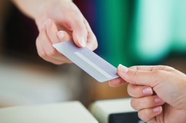 Close-up of a young woman paying with her credit card clipart