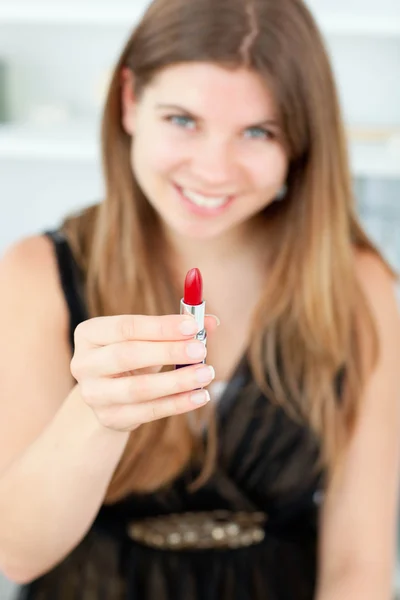 Femme souriante tenant du rouge à lèvres dans la caméra — Photo