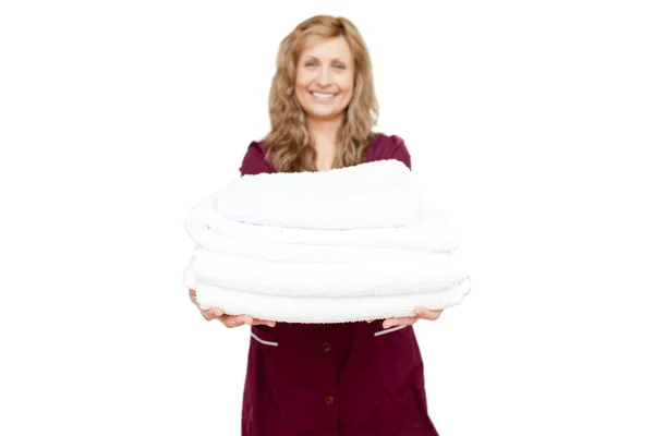 Hymyilevä nainen pitelee valkoisia pyyhkeitä — kuvapankkivalokuva