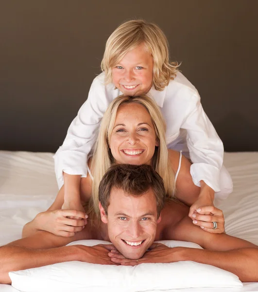 Caucasian family having fun together lying on bed — Stock Photo, Image