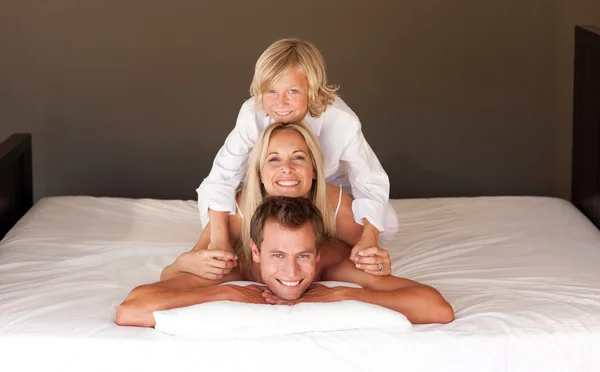 Birleşik aile birlikte eğleniyor yatakta yatarken — Stok fotoğraf