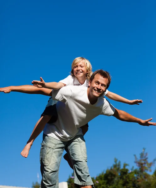 Attractive father with his son on his back outdoor — Stock Photo, Image