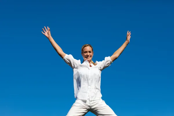 Porträt einer niedlichen Frau, die im Freien in die Luft springt — Stockfoto
