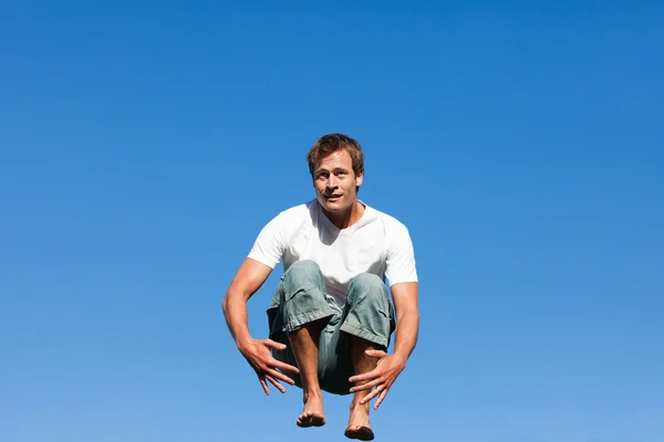 Mladý muž skákání ve venkovním vzduchu — Stock fotografie