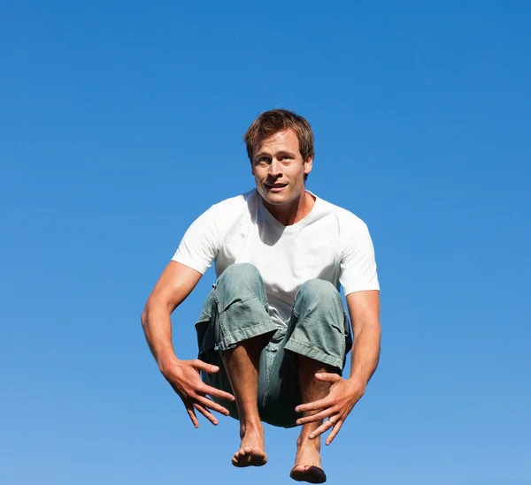 Кавказский человек прыгает в воздух под открытым небом — стоковое фото