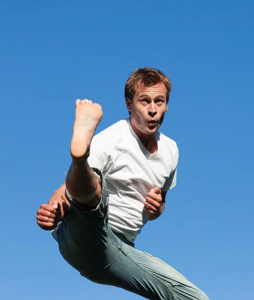 Lächelnder Mann springt im Freien in die Luft — Stockfoto