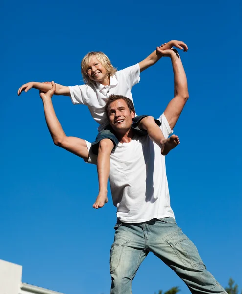 Joven padre con su hijo en su espalda al aire libre — Foto de Stock