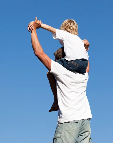 Caucasiano pai com seu filho em suas costas ao ar livre — Fotografia de Stock