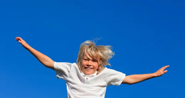 Happy kid hoppar i luften utomhus — Stockfoto
