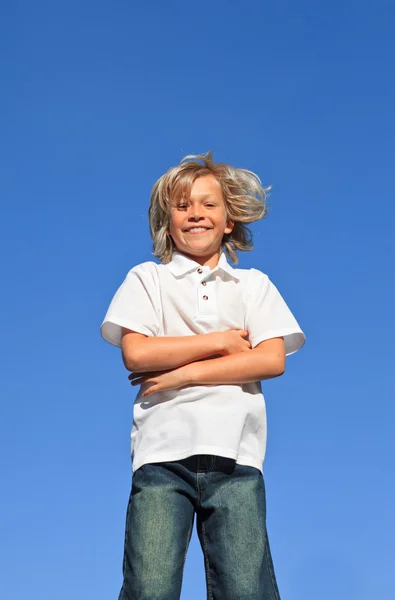 Criança confiante com os braços dobrados se divertindo ao ar livre — Fotografia de Stock