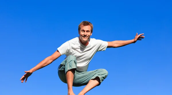 Красивый мужчина прыгает в воздух на открытом воздухе — стоковое фото