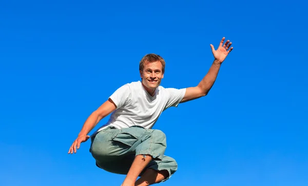 Homem confiante pulando no ar ao ar livre — Fotografia de Stock