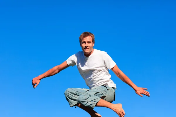 Attraktiver Mann springt im Freien in die Luft — Stockfoto