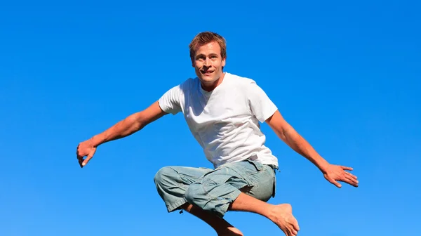Glada man hoppar i luften utomhus — Stockfoto