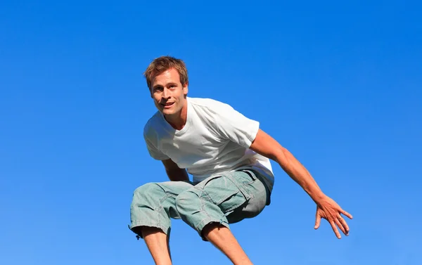 Porträt eines glücklichen Mannes, der im Freien in die Luft springt — Stockfoto
