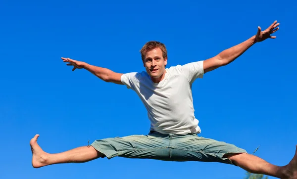 Портрет симпатичного мужчины, прыгающего в воздухе на открытом воздухе — стоковое фото