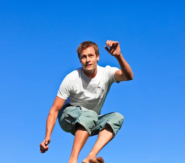 Porträt eines gutaussehenden Mannes, der im Freien in die Luft springt — Stockfoto