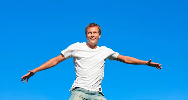 Portret van een aantrekkelijke man springen in de lucht buiten — Stockfoto