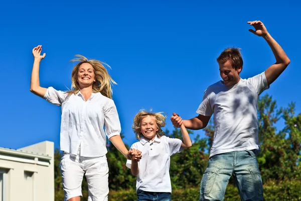 Família caucasiana positiva brincando no jardim — Fotografia de Stock