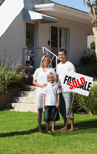 Happy family in front of their new house — Stock Photo, Image