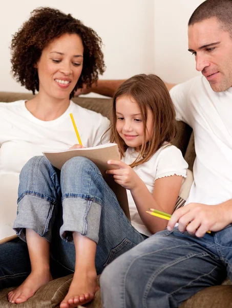 Cute girl sitting between her parents — Stock Photo, Image
