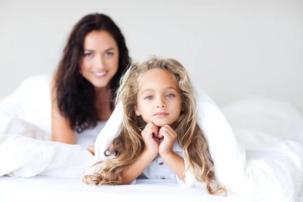 Menina bonita com cabelo loiro deitado na cama — Fotografia de Stock
