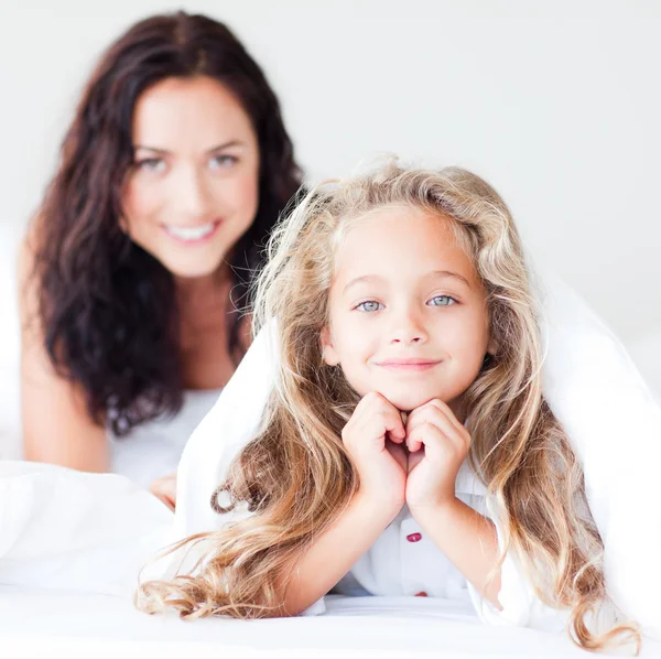 Junge Mutter und ihre Tochter auf dem Bett — Stockfoto