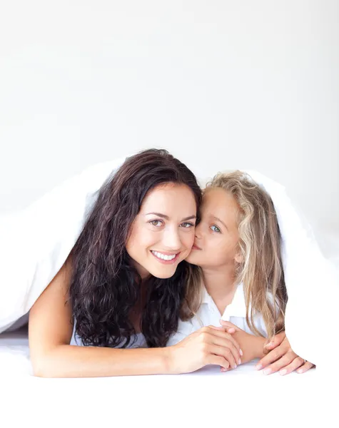 Szczęśliwa dziewczyna całuje matkę uśmiechający się — Zdjęcie stockowe