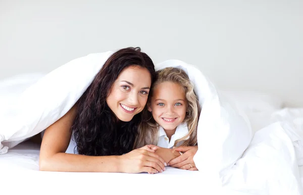 Young family lying on the bed — Stock Photo, Image