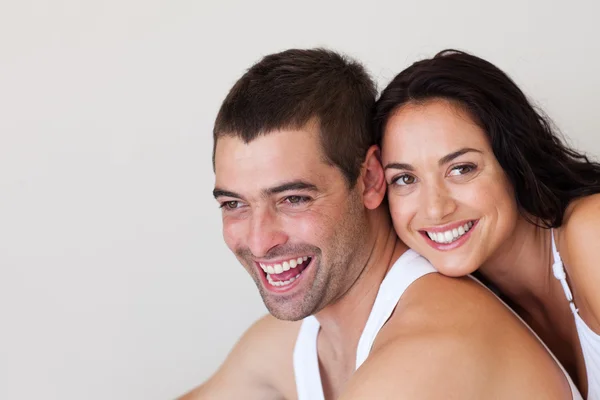 Uśmiechający się para siedzi na łóżku — Zdjęcie stockowe