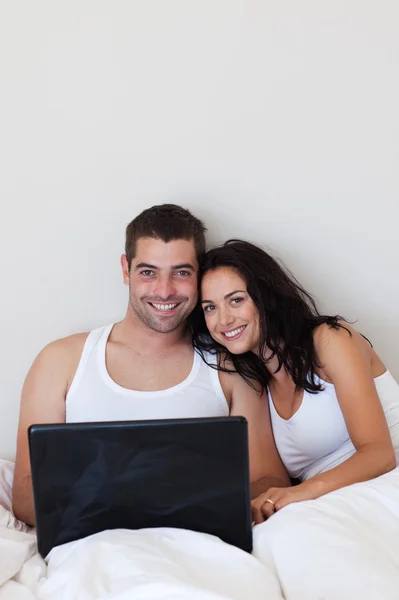 Φιλικό ζευγάρι χρησιμοποιώντας ένα φορητό υπολογιστή που βρίσκεται — Φωτογραφία Αρχείου