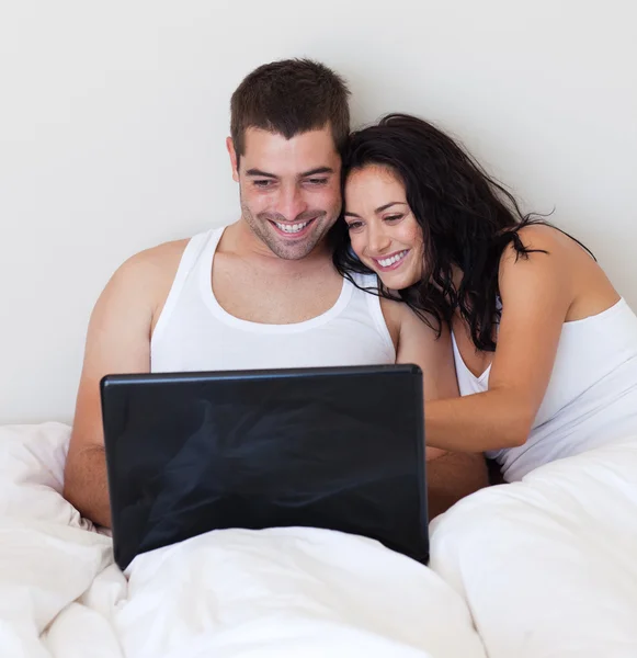 Casal animado usando um laptop em casa — Fotografia de Stock