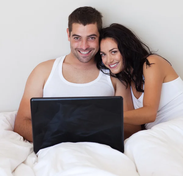 Jolly pareja usando un ordenador portátil en casa —  Fotos de Stock