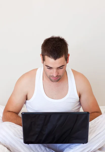 Çekici bir adam bir dizüstü bilgisayar kullanarak — Stok fotoğraf