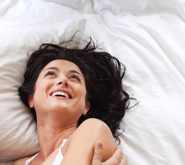 Gülümseyen güzel kadın yatakta eğleniyor — Stok fotoğraf