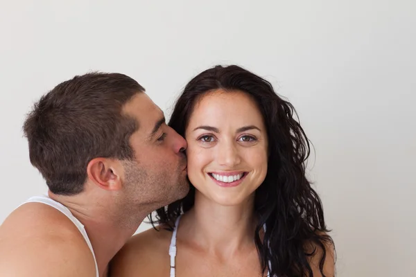 Homem atraente beijando sua namorada sorridente — Fotografia de Stock