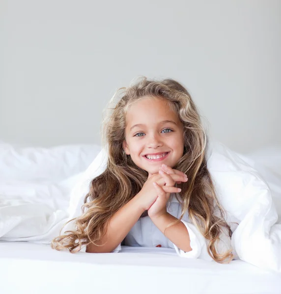 Menina alegre em uma cama — Fotografia de Stock