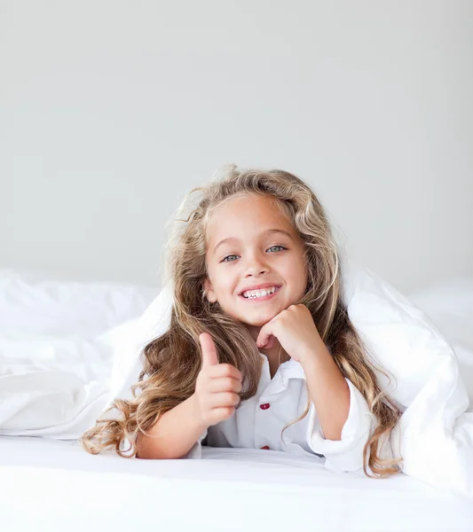 Little cute girl lying on her white bed — Stock Photo, Image
