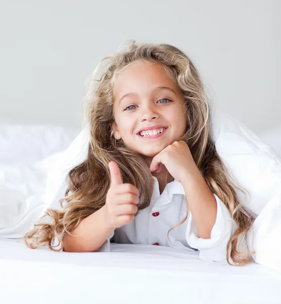 Menina radiante em uma cama branca — Fotografia de Stock