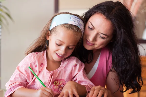 Brunette mother with blond daughter painting together — Stock Photo, Image