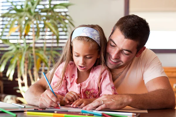 Verbaasd meisje tekenen met haar glimlachend vader — Stockfoto