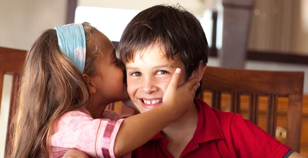Sweet girl tells her brother a secret — Stock Photo, Image