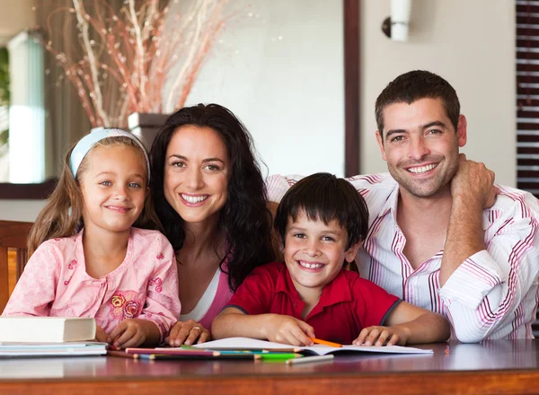 Porträt einer liebenden Familie an einem braunen Tisch — Stockfoto
