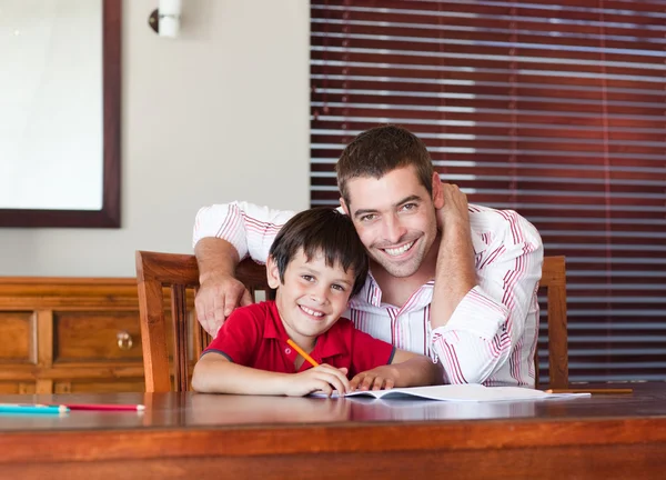 Szczęśliwy ojciec z synem, siedzi przy stole — Zdjęcie stockowe