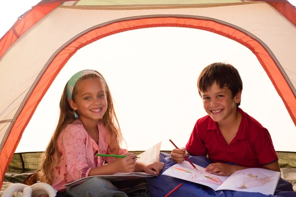 Smiling siblings in a tent — Stock Photo, Image