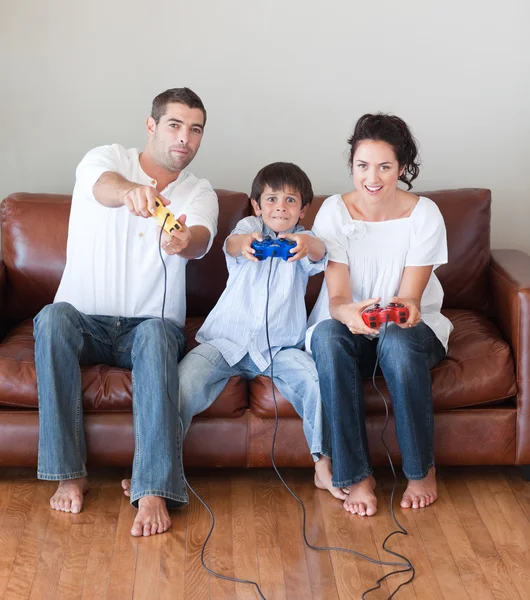 Mladá rodina na gauči hraní videoher — Stock fotografie
