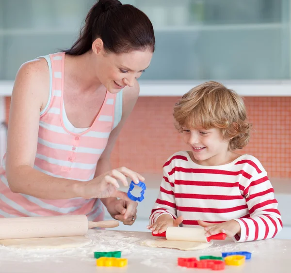 微笑的男孩与他的母亲和 cookie 的刀具 — 图库照片