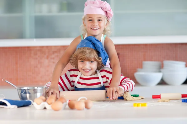 Sarışın kız onun küçük kardeşi ile pişirme — Stok fotoğraf