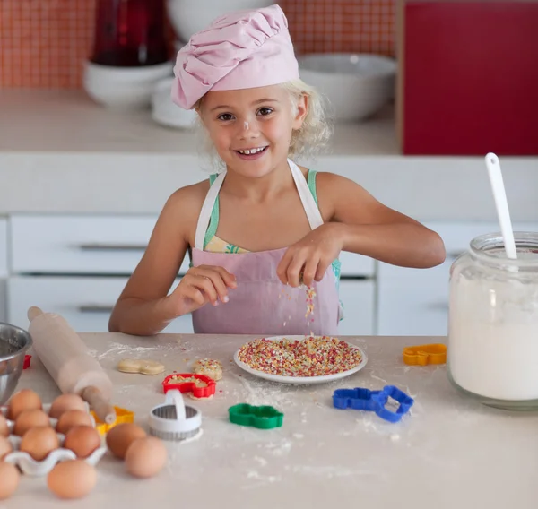 Merry little girl baking biscuit — Stock Photo, Image
